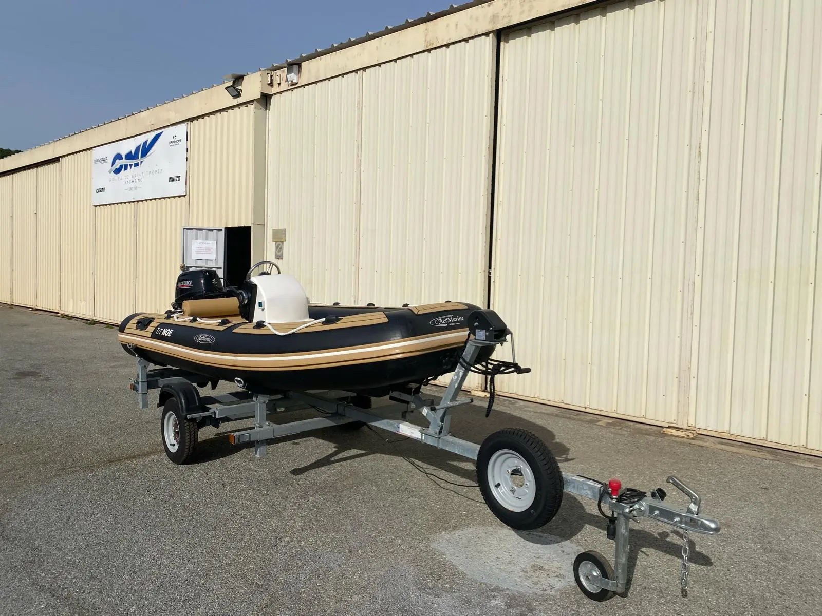 AER Marine Alusmart 350 — Bateau pneumatique sur remorque devant un bâtiment industriel.