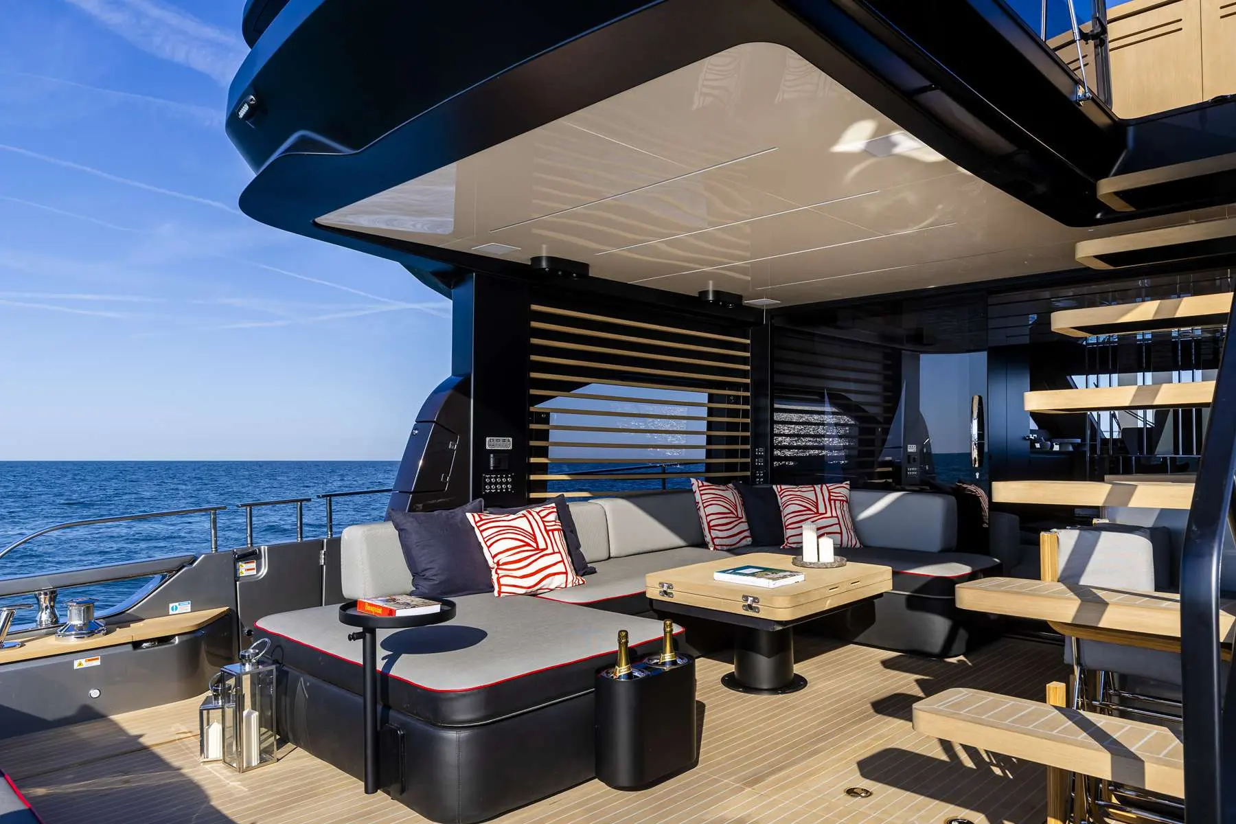 Cranchi Sessantasette 67 — Cockpit arrière aménagé avec salon en U, table et vue dégagée sur la mer.