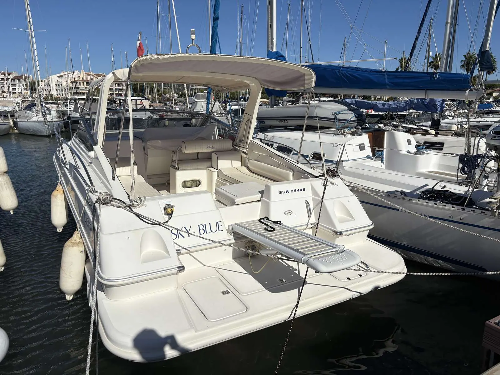 Fiart Mare Fiart 32 — Vue arrière d’un bateau à moteur blanc amarré dans une marina.