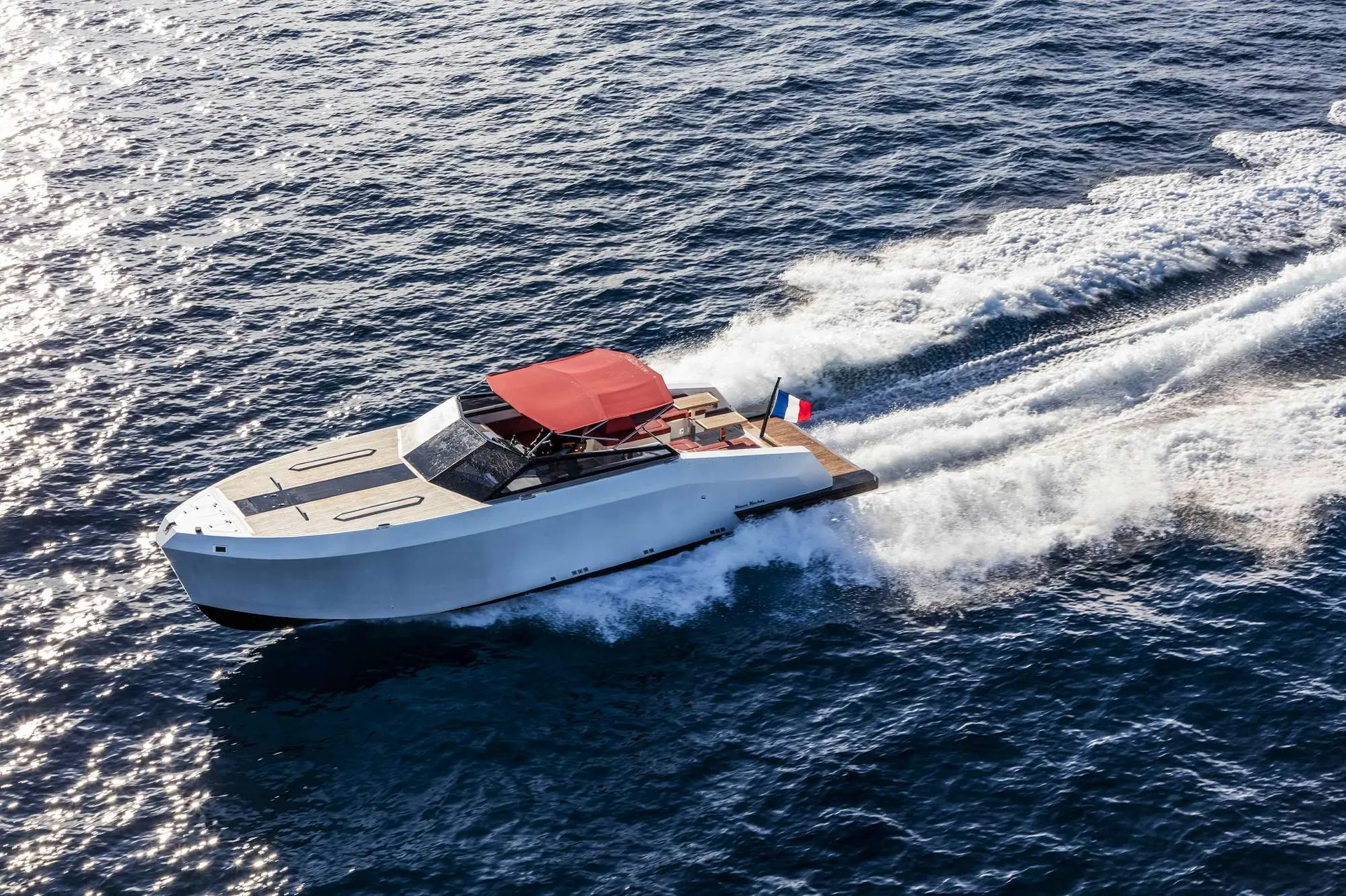 Mazu Yachts 38 — Bateau à moteur blanc vu de trois quarts, naviguant en mer avec son pavillon français.