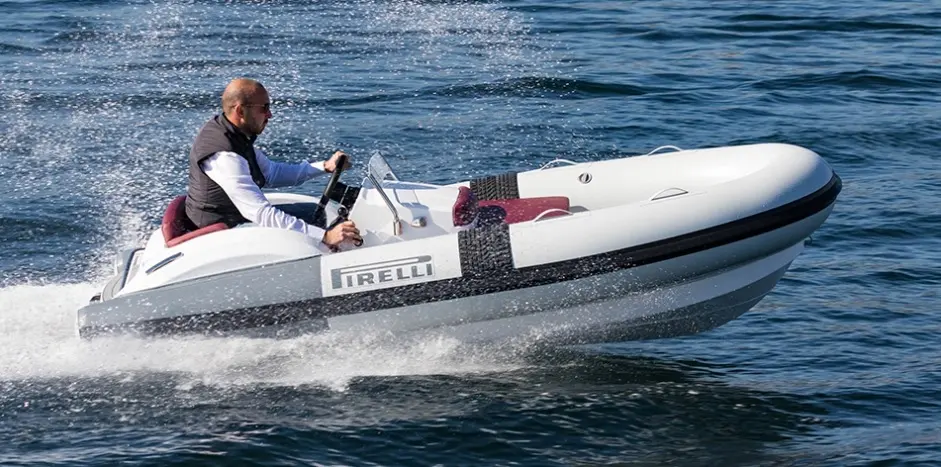 Pirelli J33 — Semi-rigide blanc marqué Pirelli naviguant à vive allure, avec un pilote à la barre.