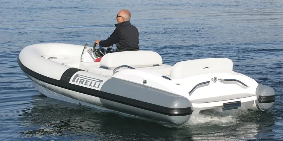 Pirelli J45 — Semi-rigide blanc vu de trois quarts arrière sur l’eau, avec un pilote à bord.