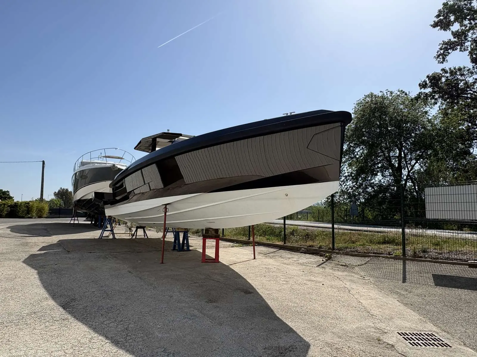 Wally 48 — Bateau à moteur blanc et noir photographié à terre, vu de trois quarts avant.