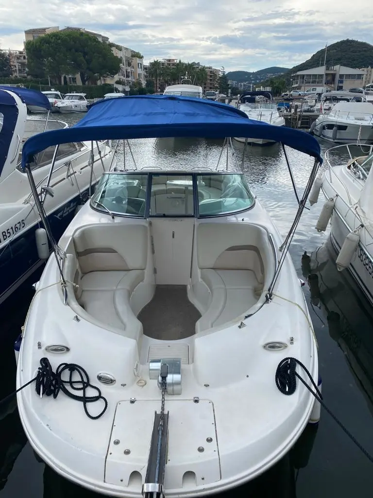 Chaparral Sunesta 274 — Vue plongeante de l’avant d’un bateau blanc amarré dans une marina.