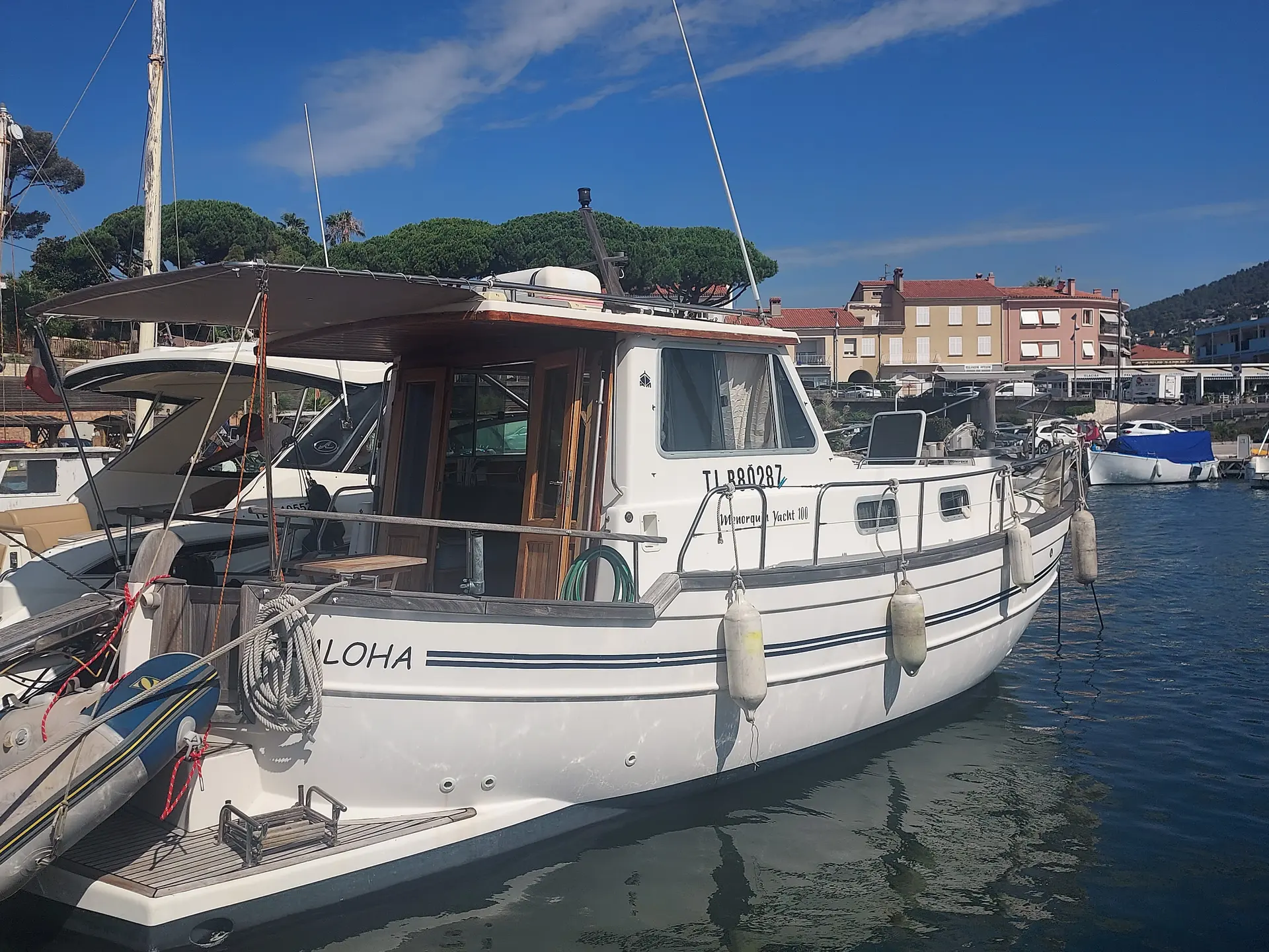 Menorquin 100 Yacht — Vue trois quarts d’un bateau à moteur amarré dans un port.