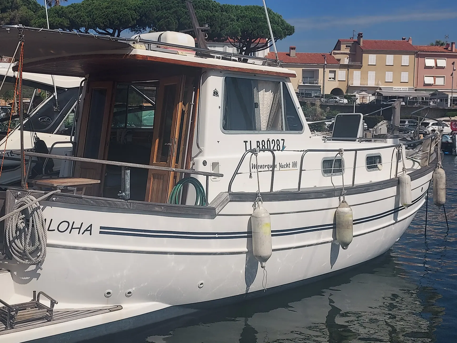 Menorquin 100 Yacht — Bateau à moteur amarré dans un port, photographié de trois quarts arrière.