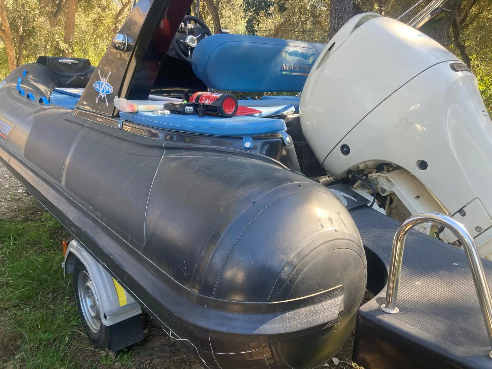 Master Summer — Vue rapprochée de l’arrière d’un bateau pneumatique avec moteur hors-bord
