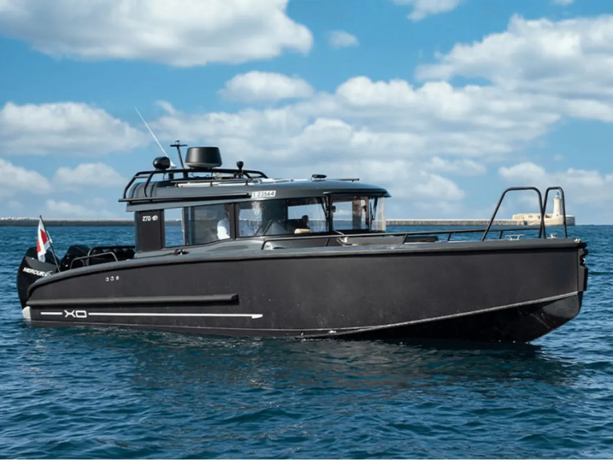 XO Boats XO 270 RS Front Cabin — Bateau à cabine noire photographié de profil sur une mer calme
