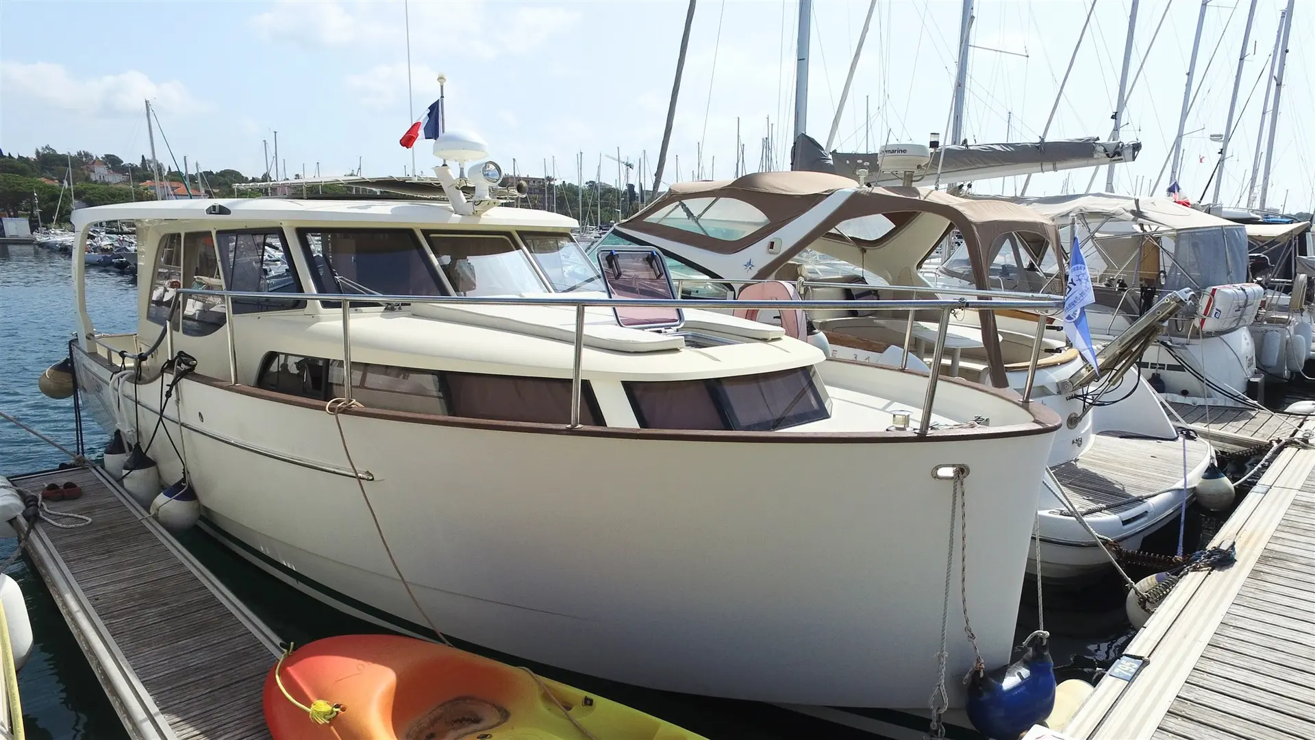 Greenline 33 Hybrid Electrique — Bateau à moteur amarré dans un port, photographié de trois quarts avant.