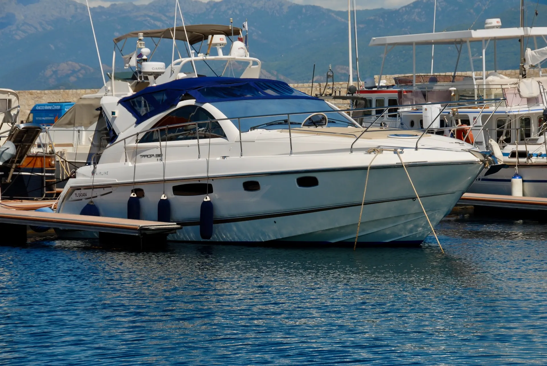 Fairline Targa 38 — Bateau à moteur blanc et bleu amarré dans une marina alpine.