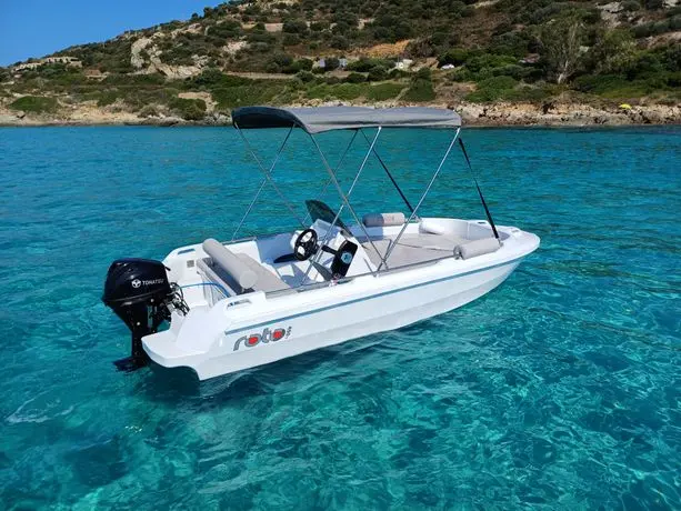 Roto 450 S — Bateau à moteur blanc vu de trois-quarts sur une mer turquoise, avec taud déployé.