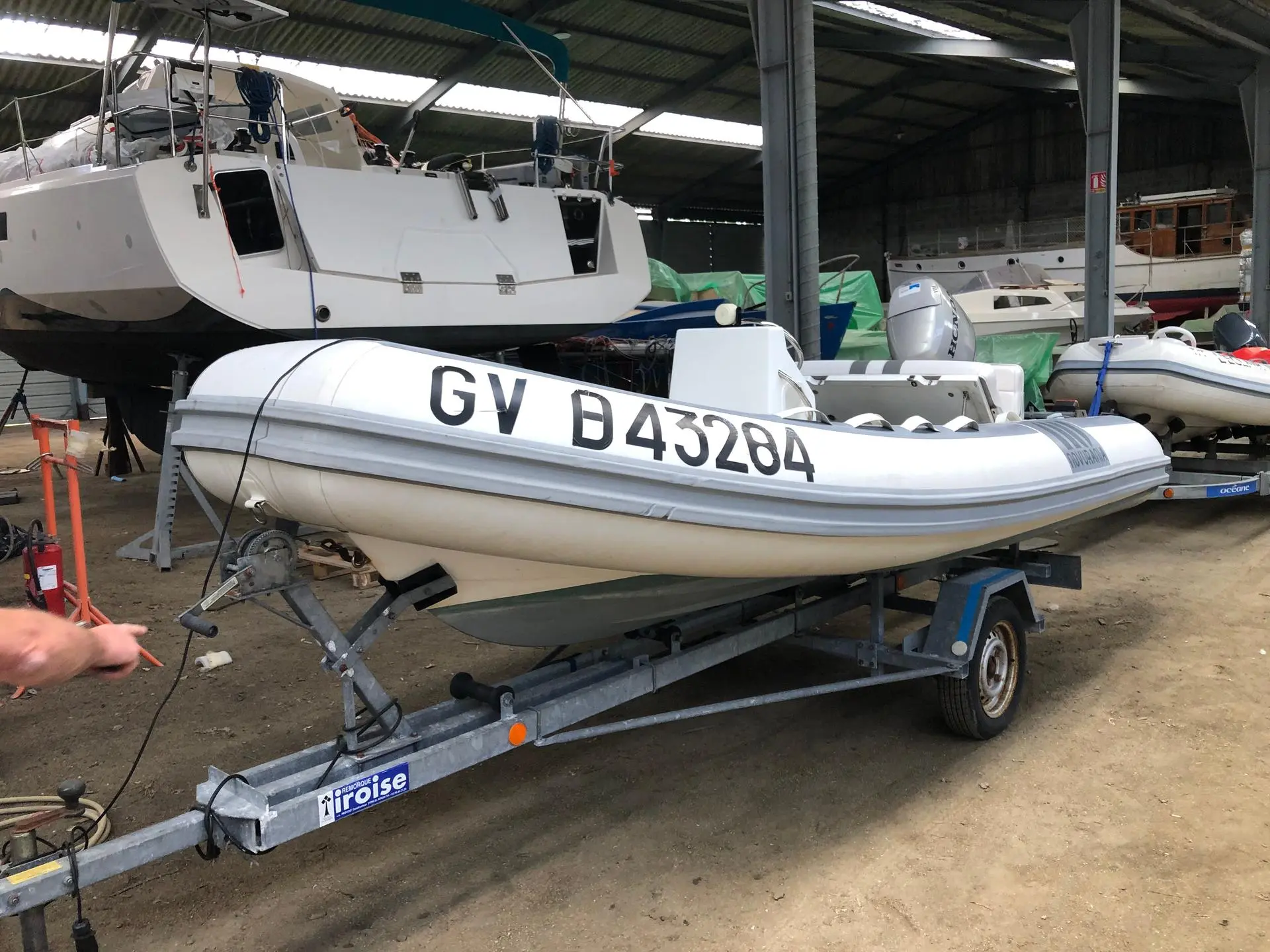 Novurania 430 DL — Bateau pneumatique blanc sur remorque dans un hangar nautique.
