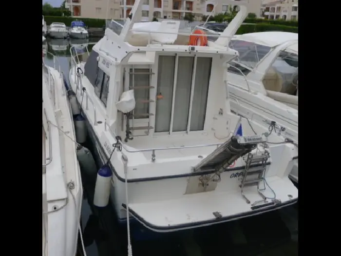 ACM 955 — Vue arrière d’un bateau blanc amarré dans une marina.