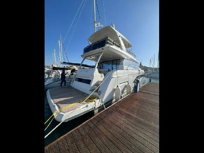 Prestige Yachts 630 Fly — Bateau blanc vu de trois quarts arrière, amarré à un ponton.