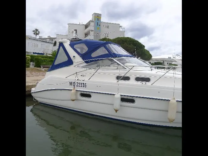 Sealine S 34 — Bateau à moteur blanc amarré, vu de profil dans un port.
