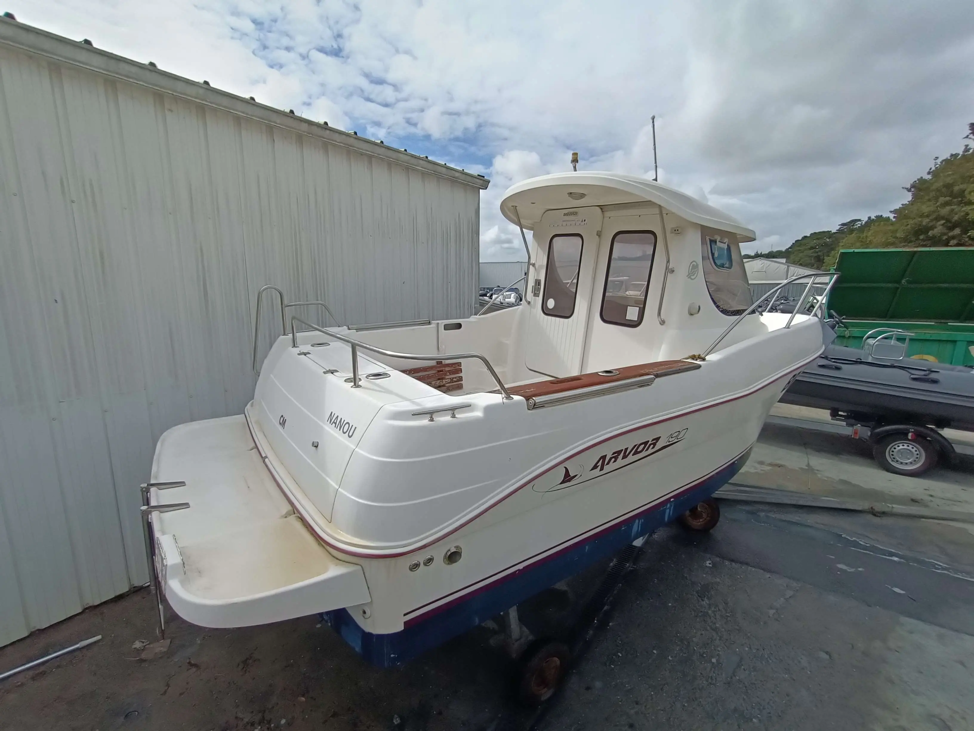 Arvor 190 — Bateau blanc vu de trois-quarts arrière sur terre-plein, avec cabine et poste de pilotage.