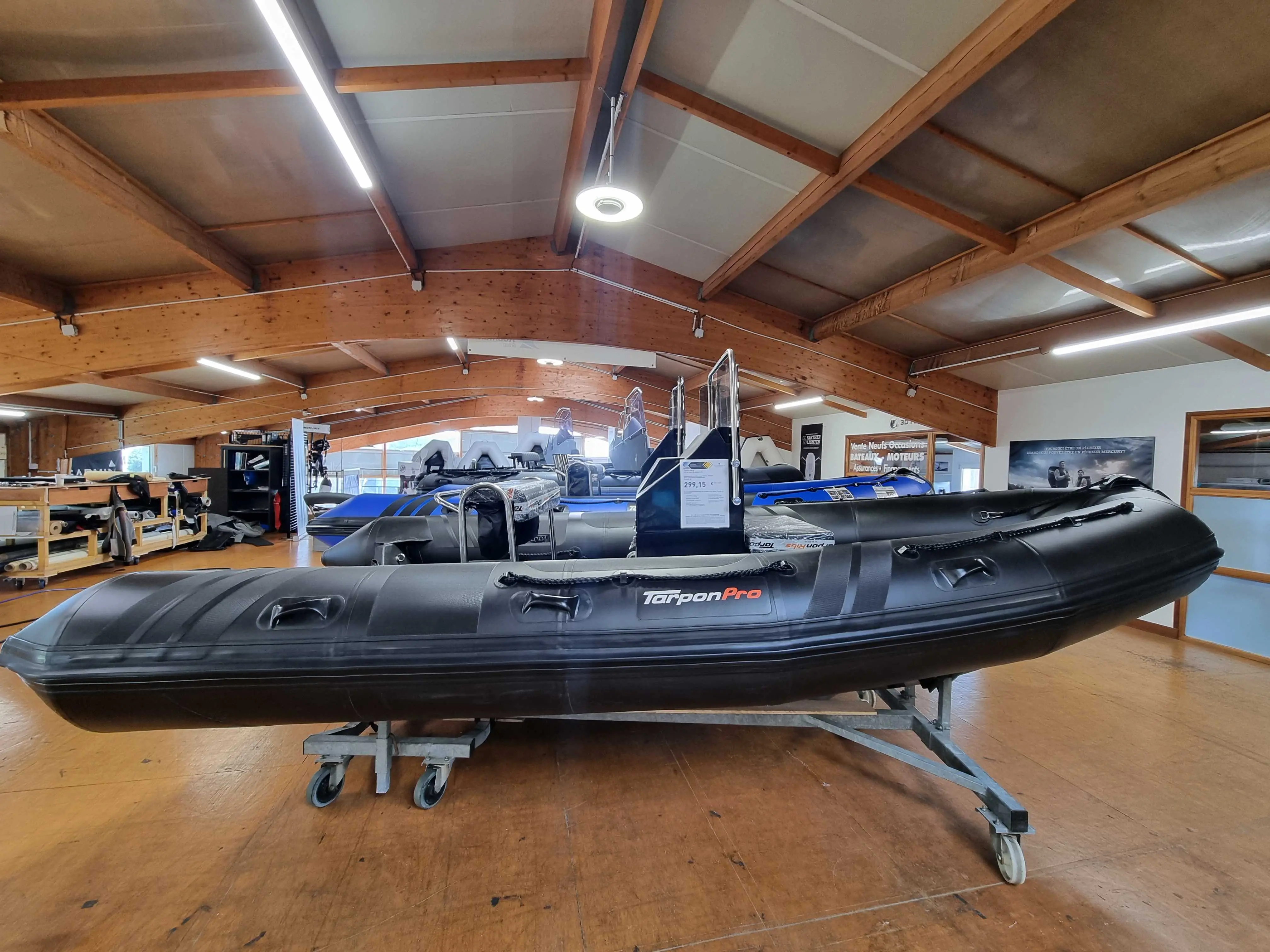 Tarpon AD 50 — Bateau semi-rigide noir présenté sur une remorque dans un espace intérieur.