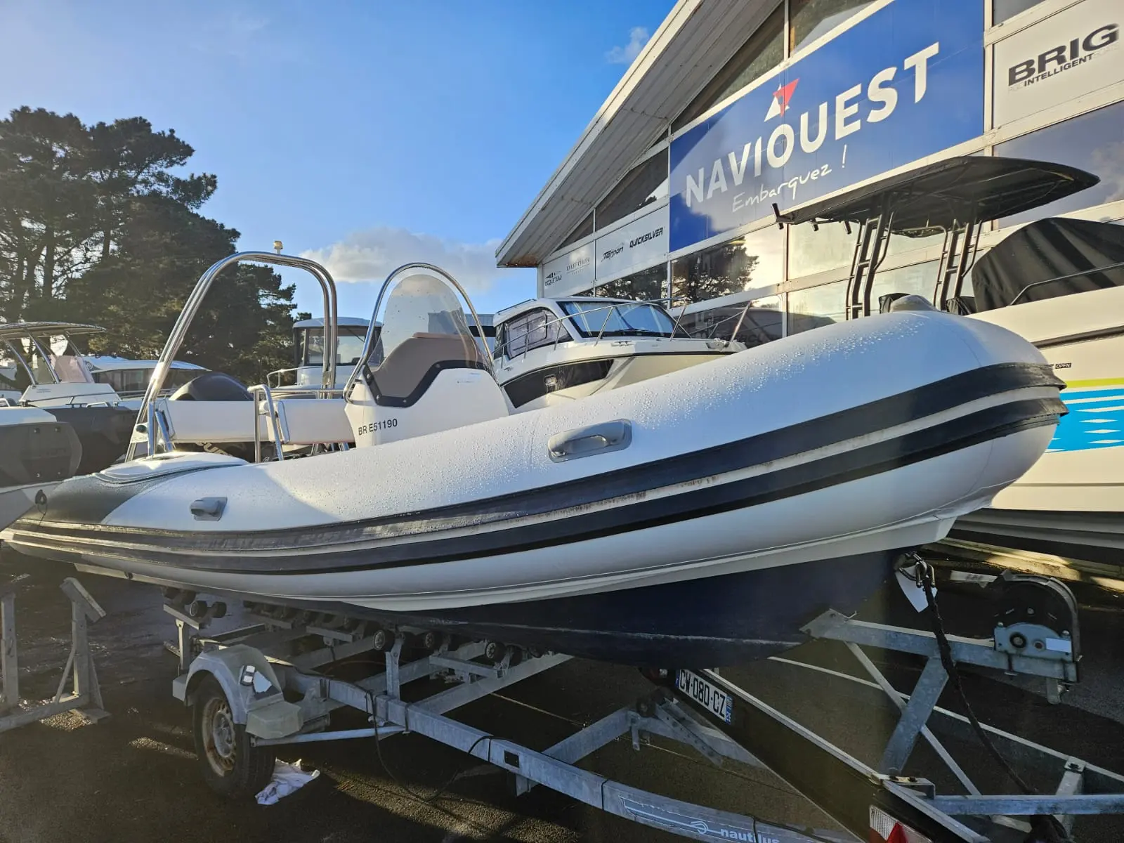 Valiant V 650 Cruiser — Bateau pneumatique à console centrale présenté sur sa remorque devant un magasin nautique.