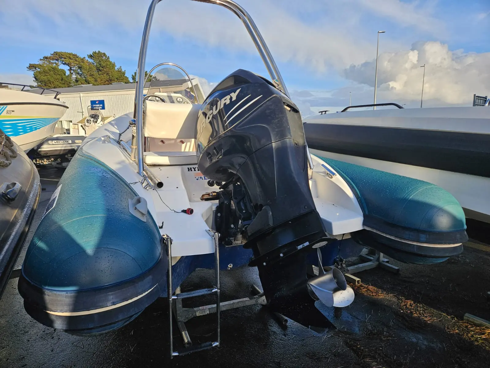 Valiant V 650 Cruiser — Vue arrière d’un semi-rigide blanc et bleu équipé d’un moteur hors-bord.