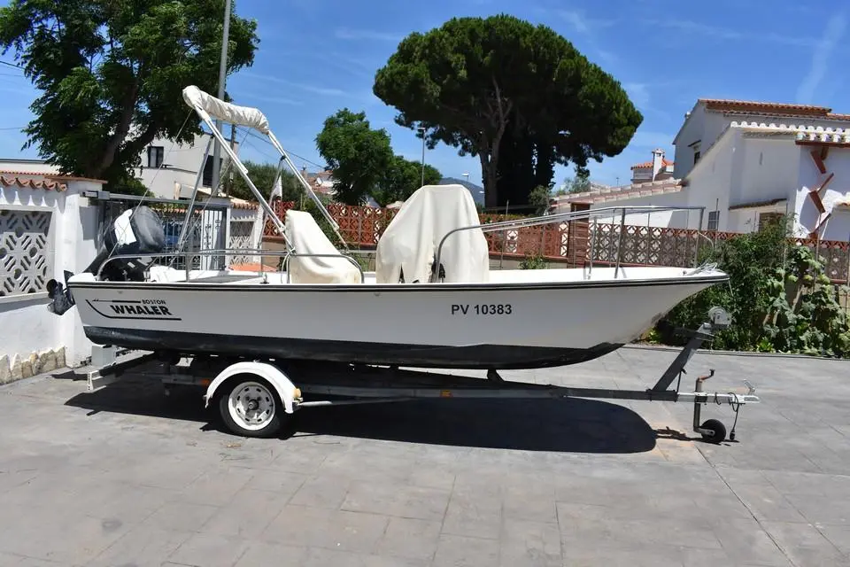 Boston Whaler 17 Montauk — Bateau blanc à console centrale présenté sur une remorque, vu de profil.
