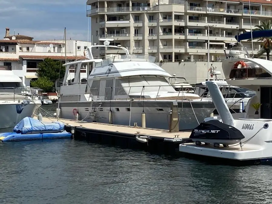 Hi Star 48 Motor Yacht — Bateau à moteur blanc amarré dans un port, vu de trois quarts.