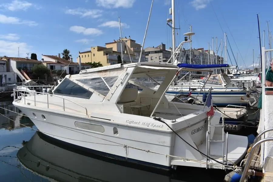Gallart 1050 — Vedette blanche amarrée dans un port, vue de trois quarts avant.
