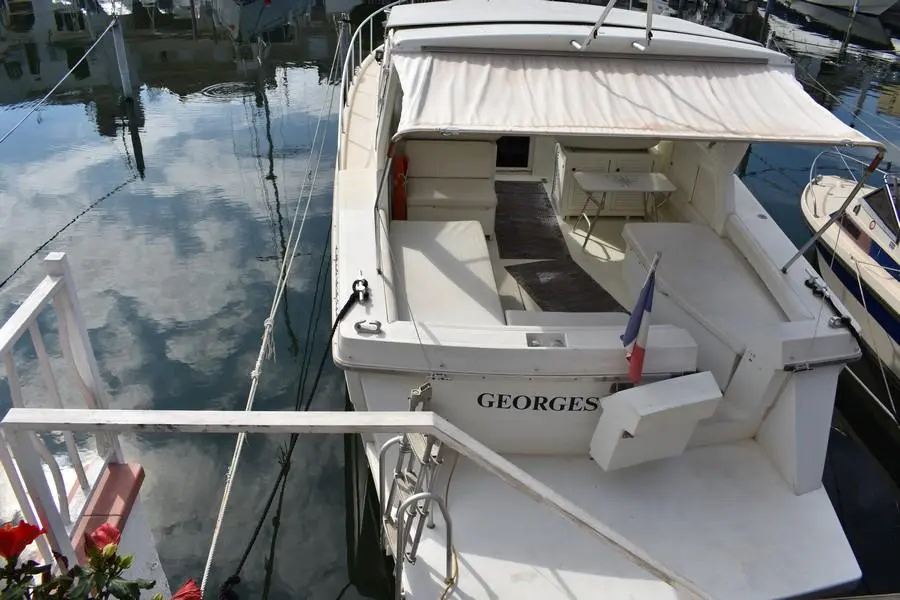 Gallart 1050 — Vue plongeante de l’arrière d’un bateau blanc amarré dans un port.