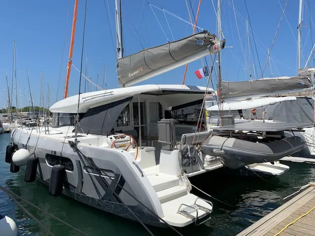 Excess Catamarans Excess 12 — Catamaran blanc amarré au port, vu de trois quarts arrière.