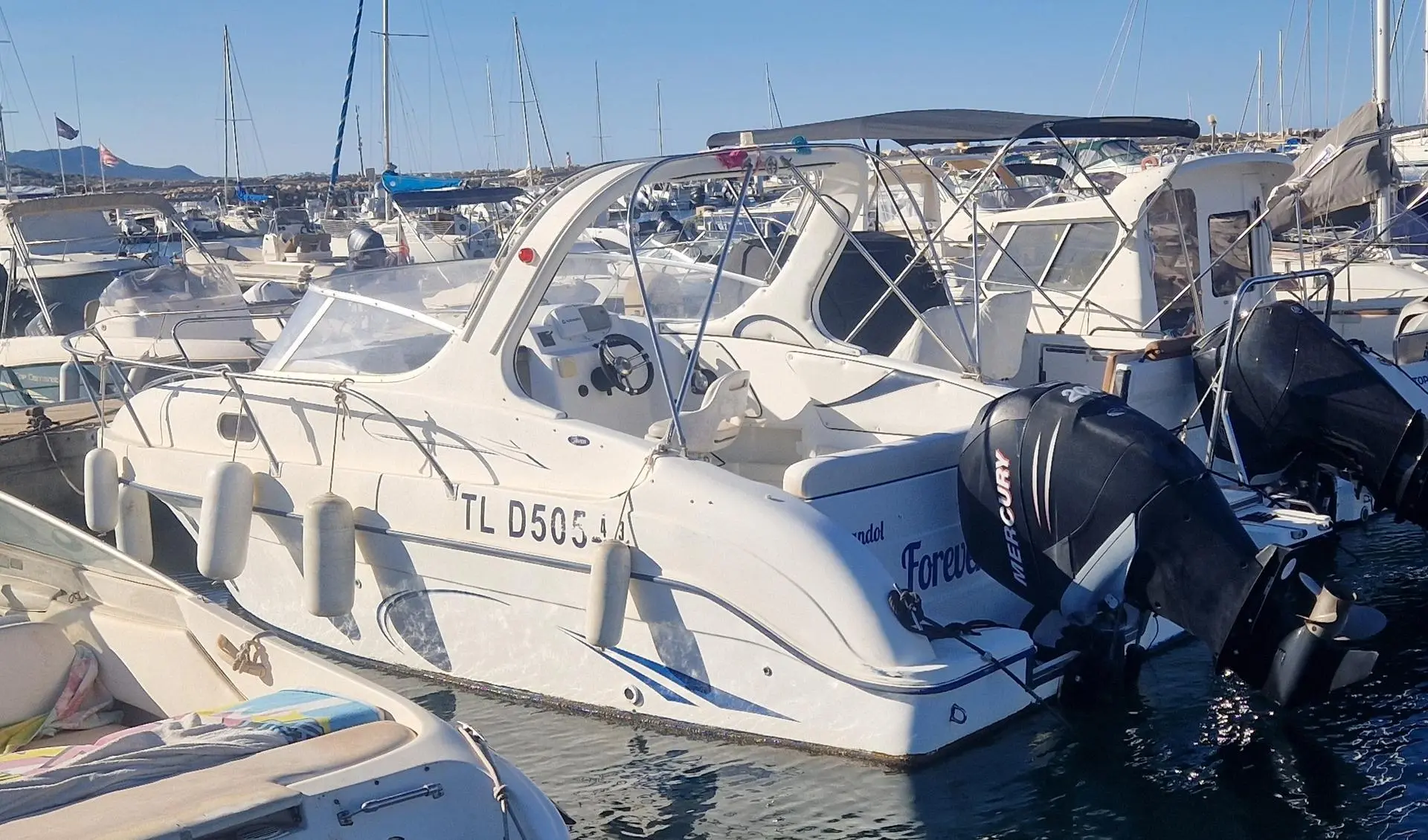 Saver 650 Cabine — Bateau à moteur blanc amarré dans un port, photographié de trois quarts arrière.