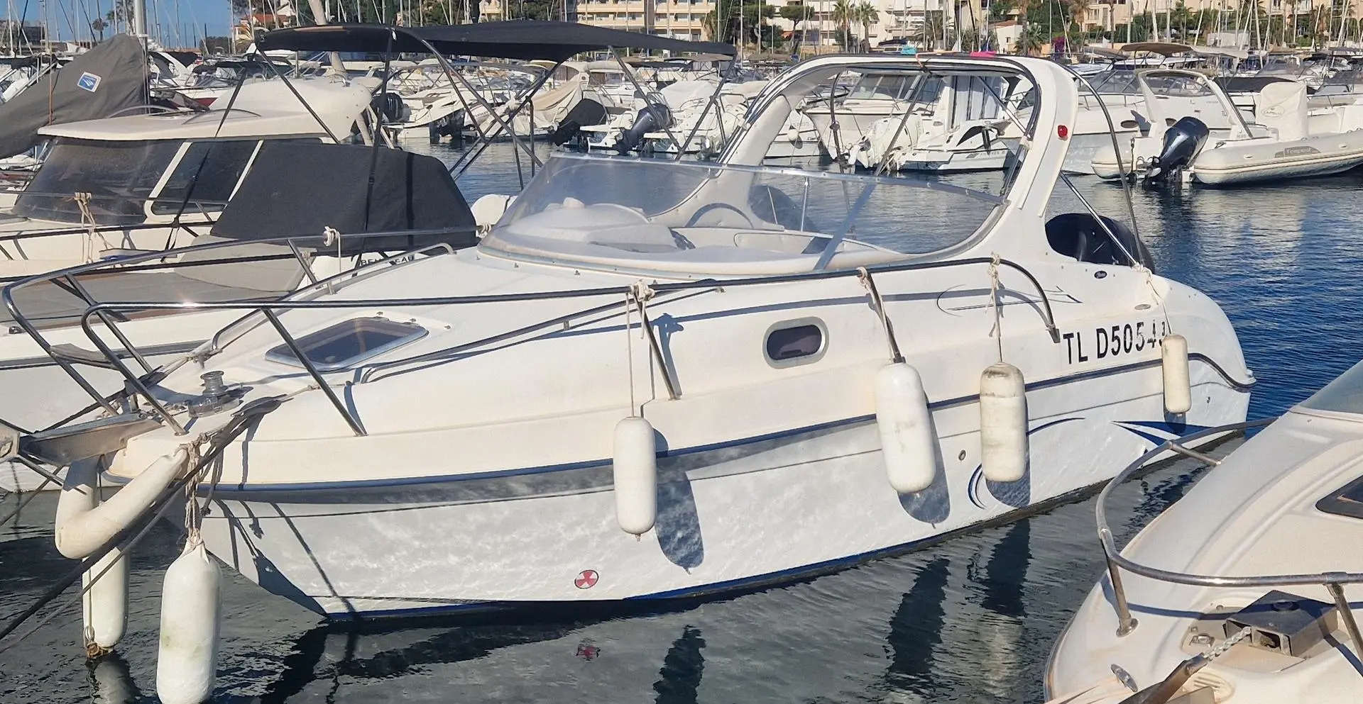 Saver 650 Cabine — Bateau à moteur blanc amarré dans un port de plaisance, vu de profil.