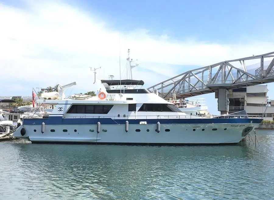Viudes 78 — Bateau à moteur blanc et bleu amarré dans un port, vu de profil.