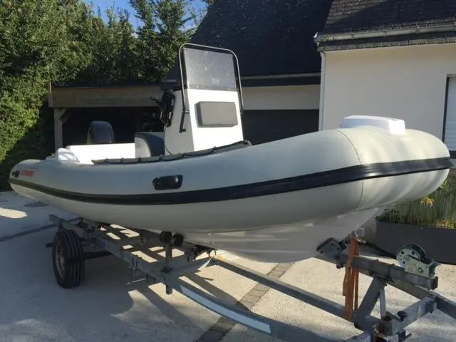 Polimarine Rib 520 — Bateau pneumatique semi-rigide blanc présenté sur sa remorque dans une cour.