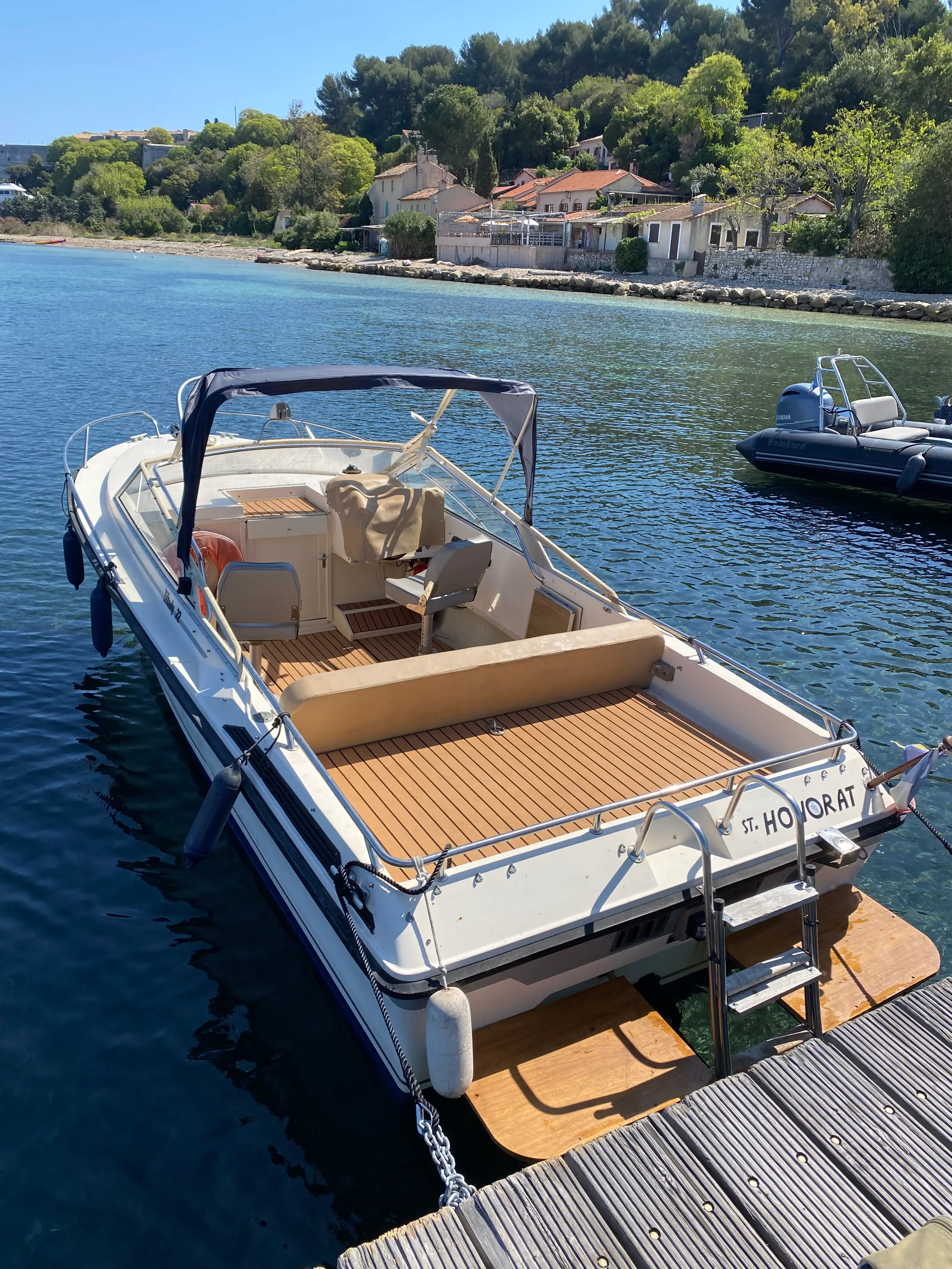 Windy 22 — Bateau à moteur amarré, vu depuis l’arrière, avec cockpit ouvert et taud.