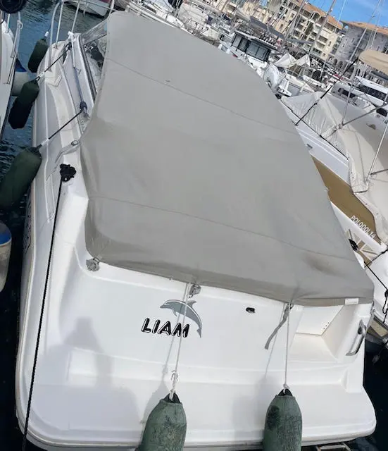 Bayliner Cierra 2355 Sunbridge — Vue plongeante de l’arrière d’un bateau blanc amarré dans un port.