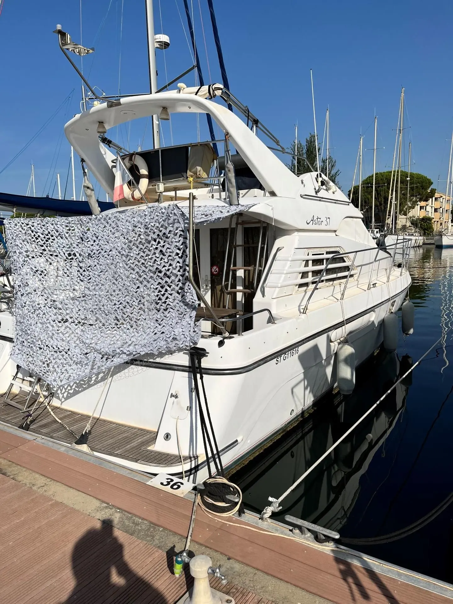 Astor 37 — Bateau à moteur blanc photographié amarré dans une marina, vu de trois quarts arrière.