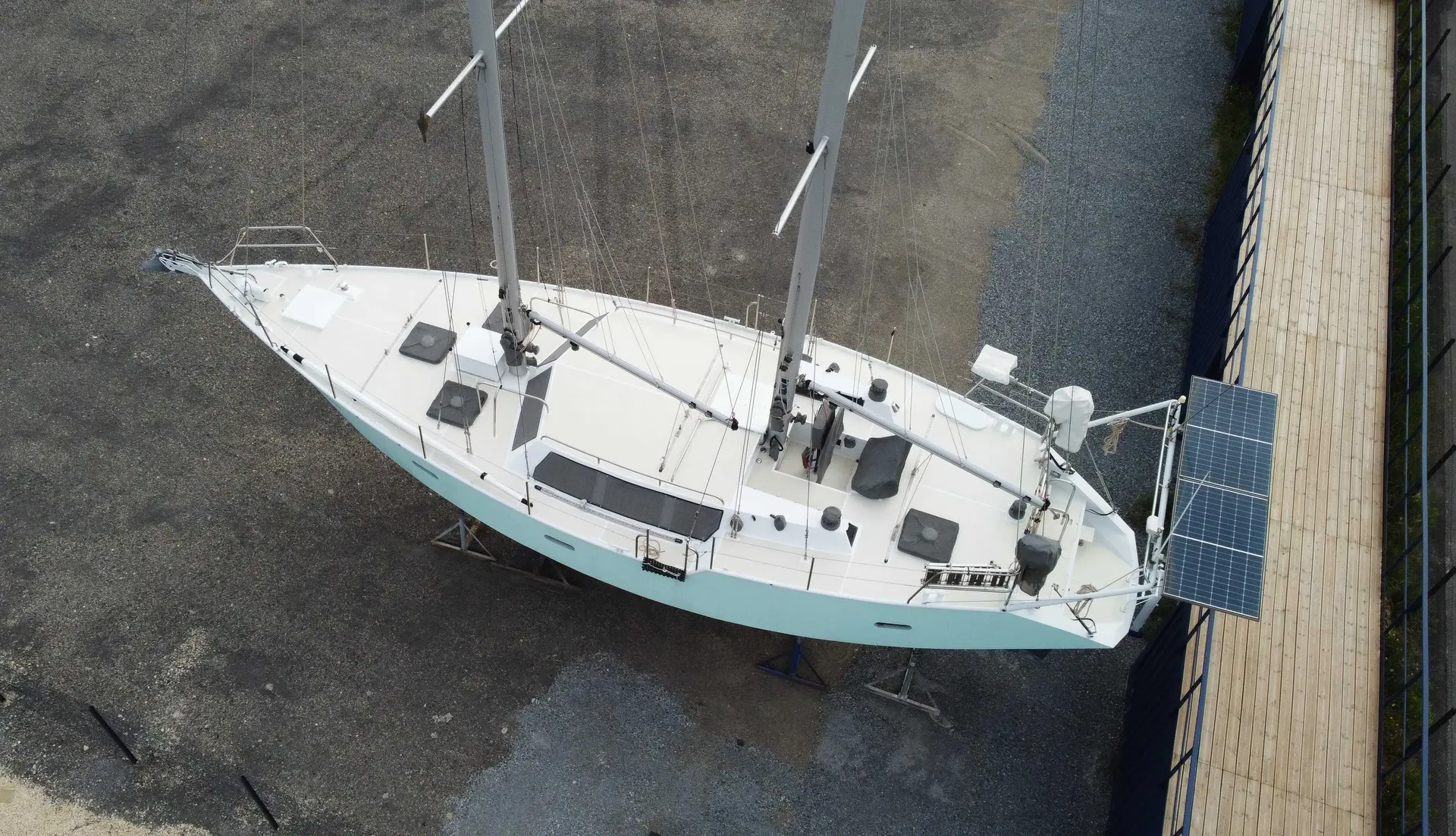 Alesia Marine Goelette 50 — Voilier blanc photographié à terre, vu de dessus près d’un bâtiment.