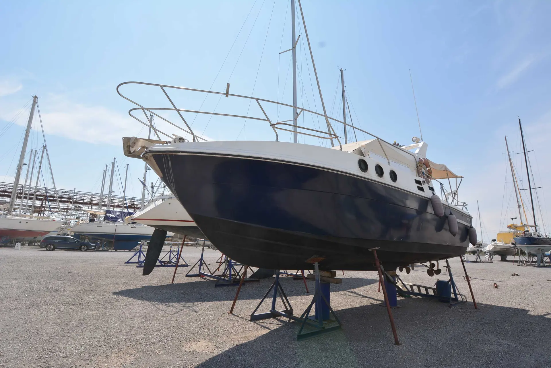 Azimut 32 — Bateau à moteur bleu et blanc photographié à terre sur des bers.