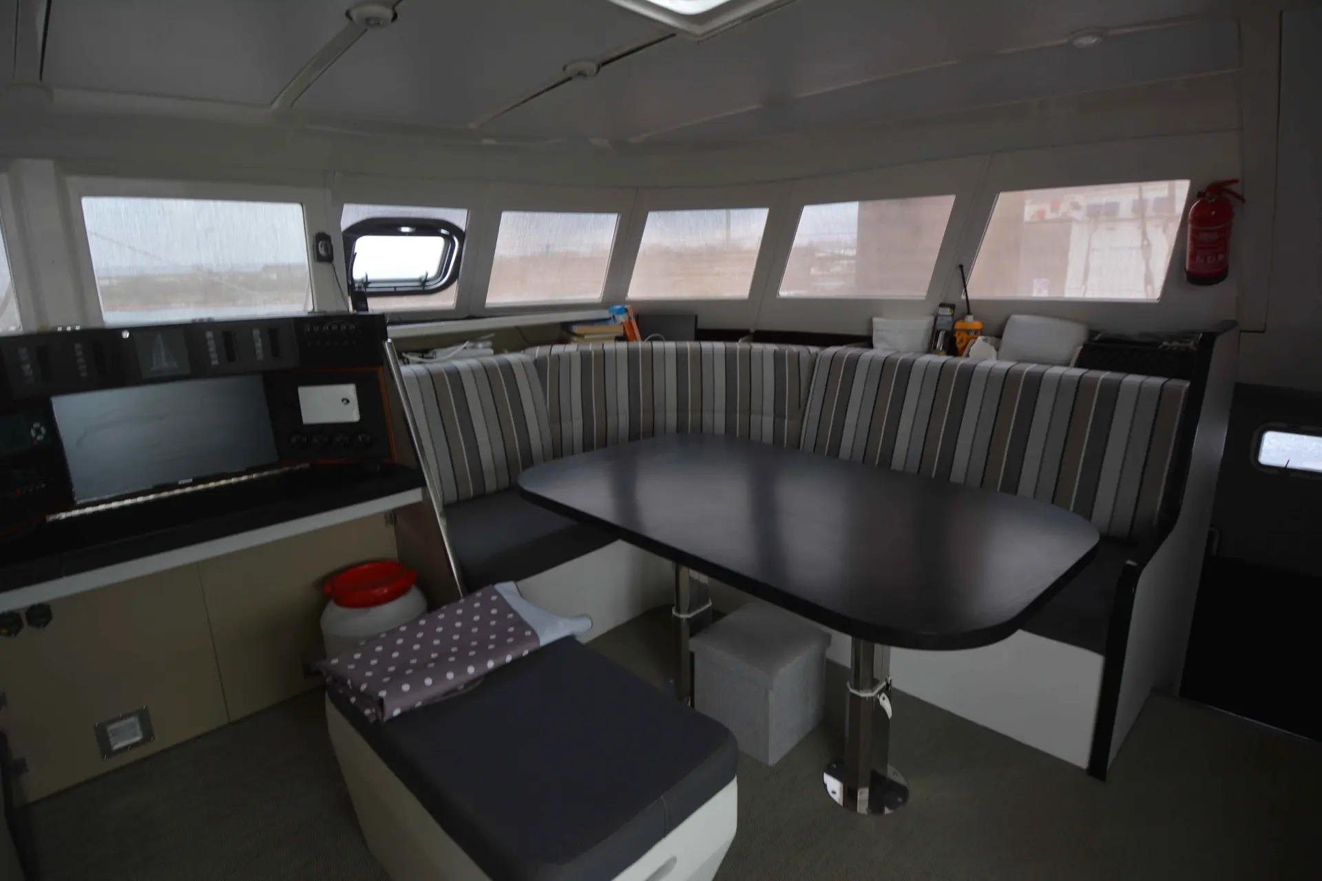 Aikane Trinidad Aikane 56 — Vue intérieure du poste de pilotage avec banquette en U et table centrale.