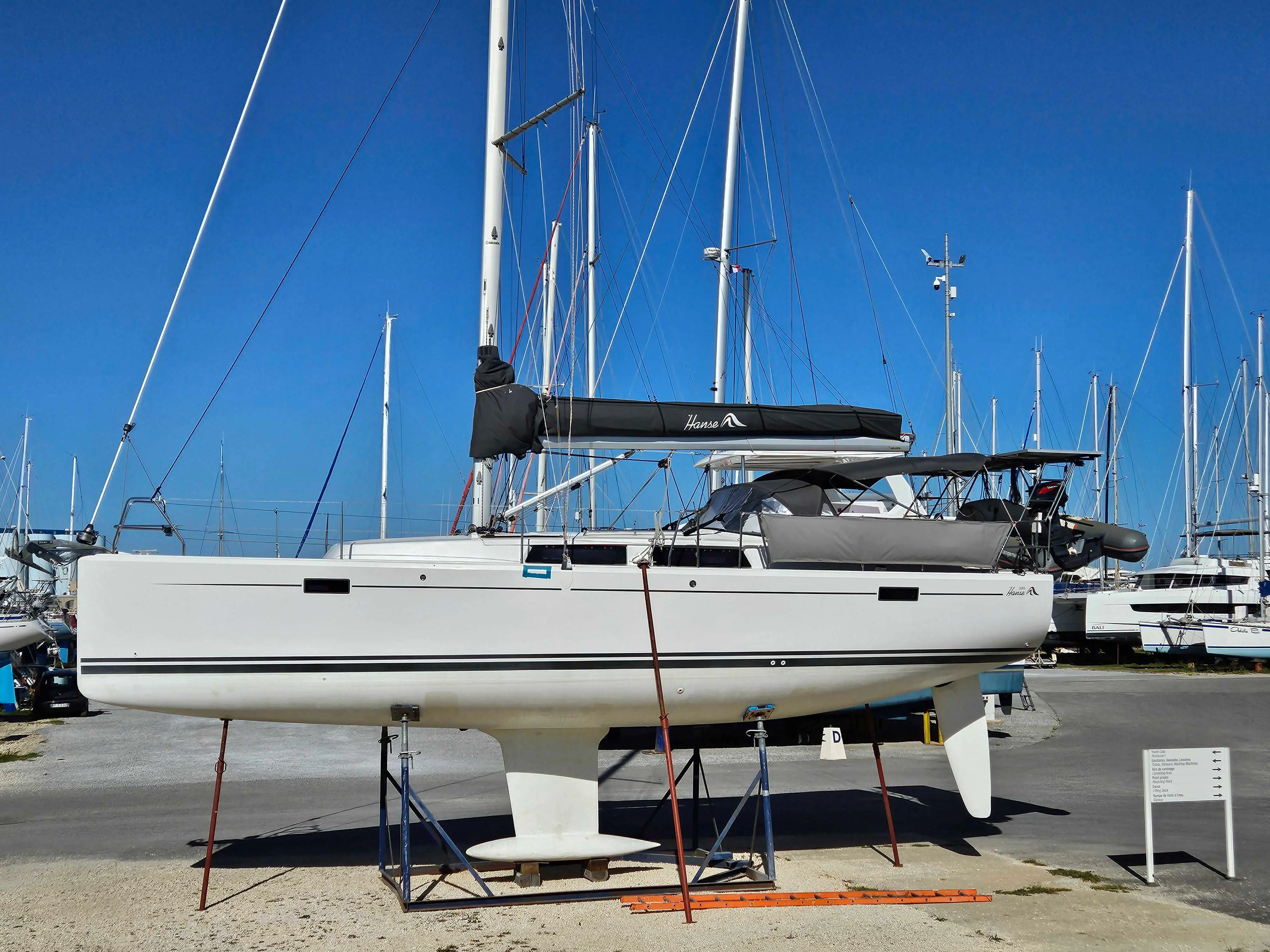 Hanse 385 — Voilier blanc vu de profil, à terre sur bers, dans une marina.