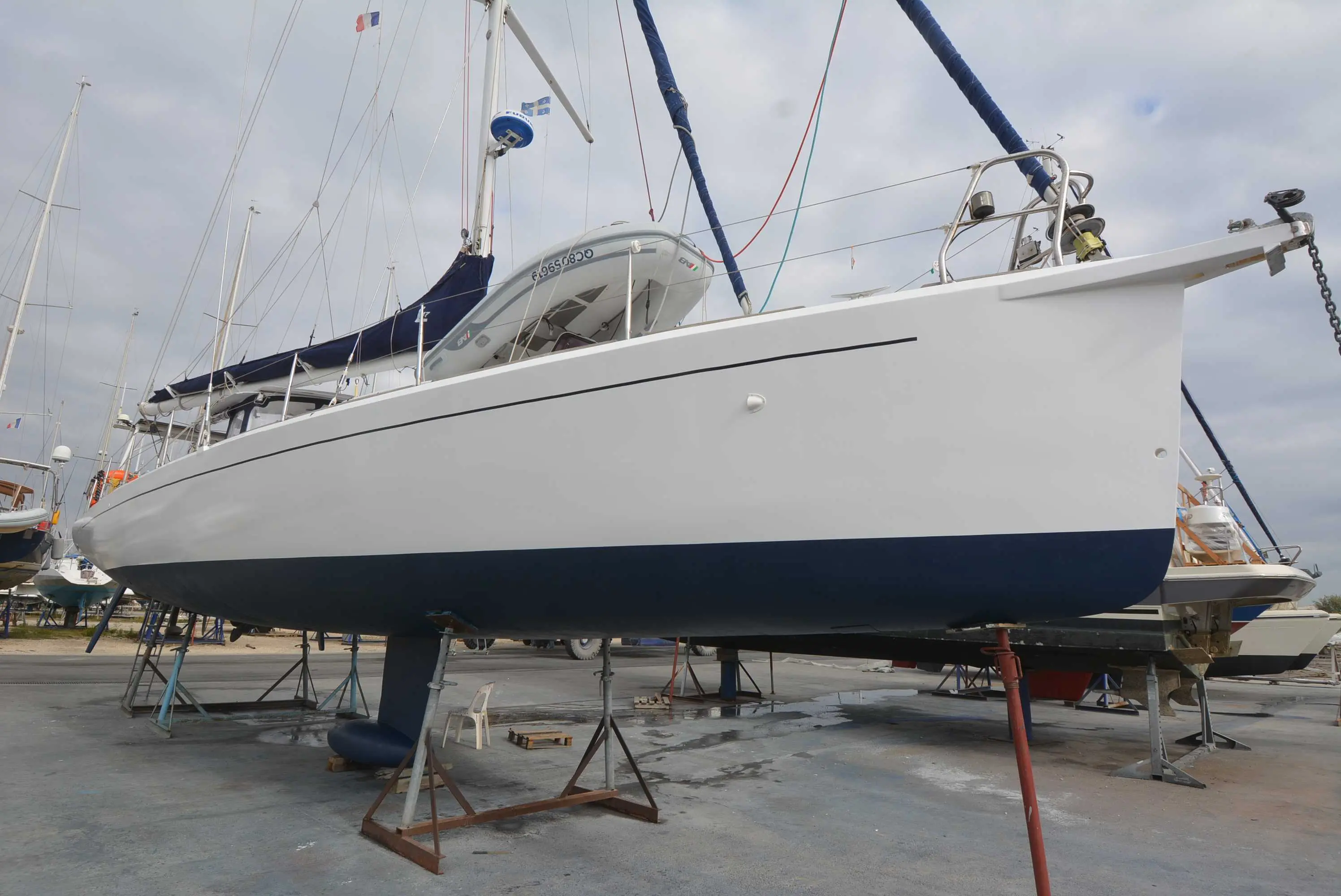 Lansart 47 — Voilier blanc à coque bleue présenté à terre dans un chantier naval.