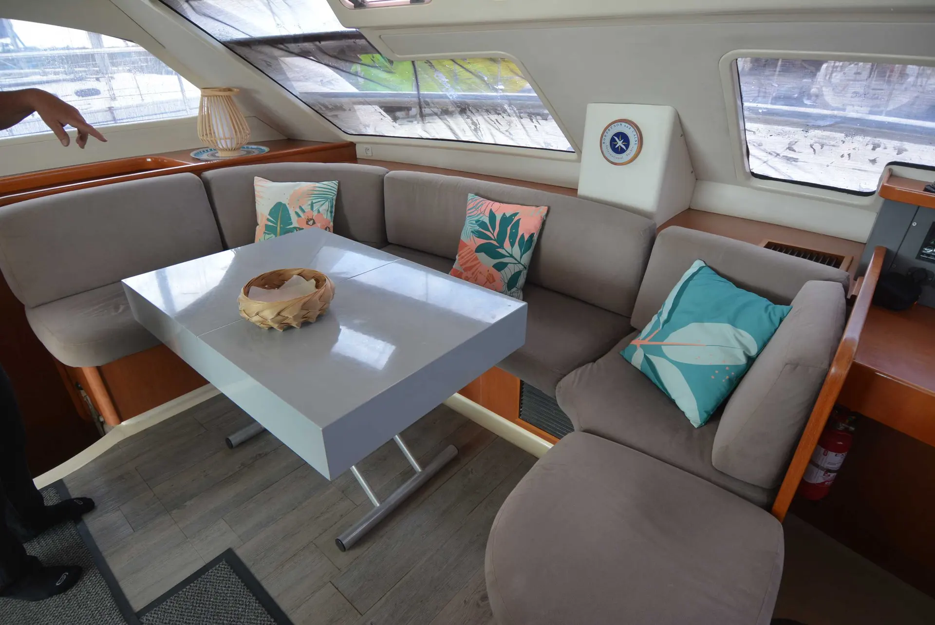 Leopard 47 PC — Salon intérieur d’un catamaran avec banquettes, table et coussins.
