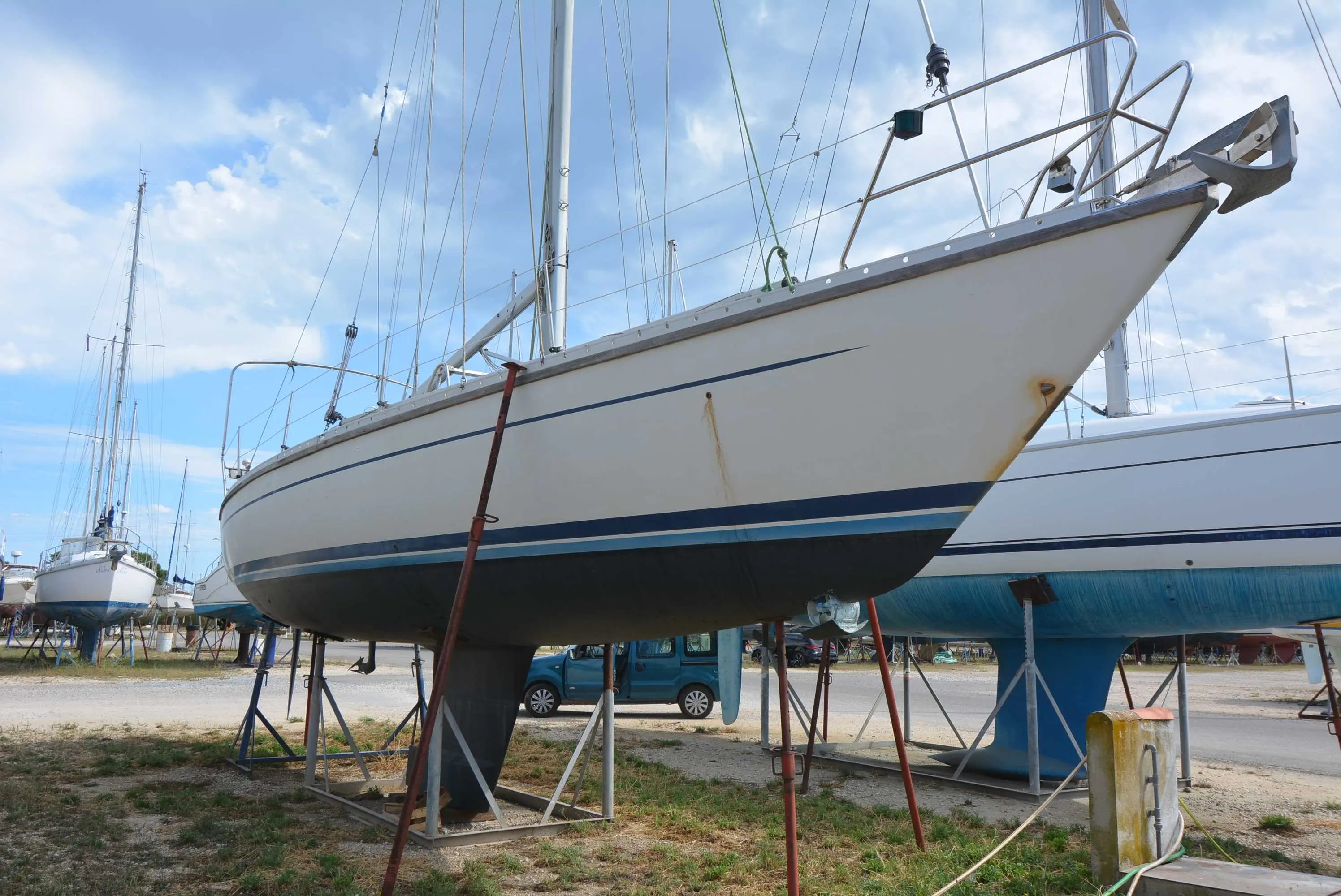 Luffe 46 — Voilier blanc à liserés bleus, photographié à terre sur bers dans un chantier naval.
