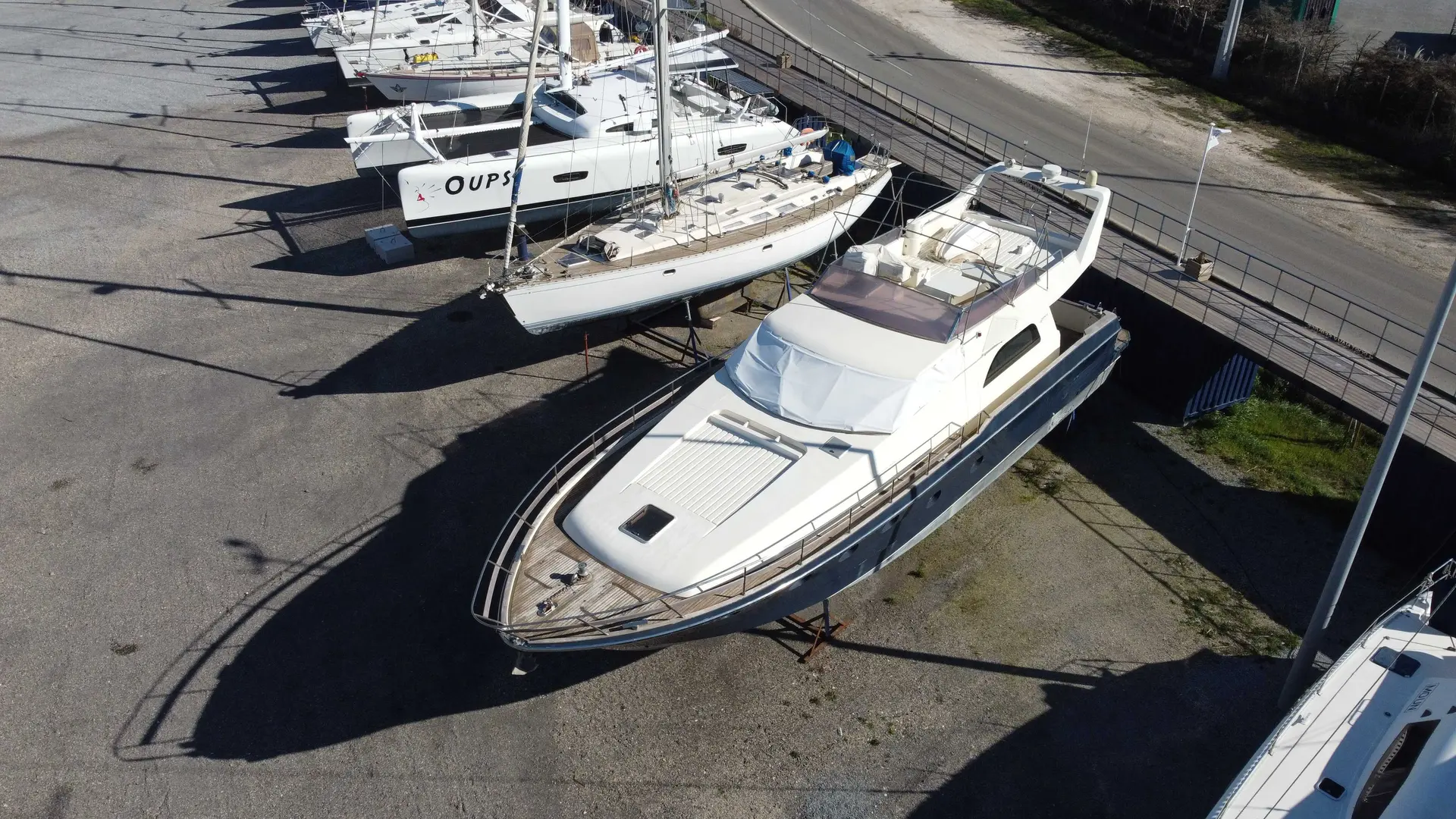 Marchi 65 — Bateau à moteur blanc photographié à terre, vu de trois quarts avant.