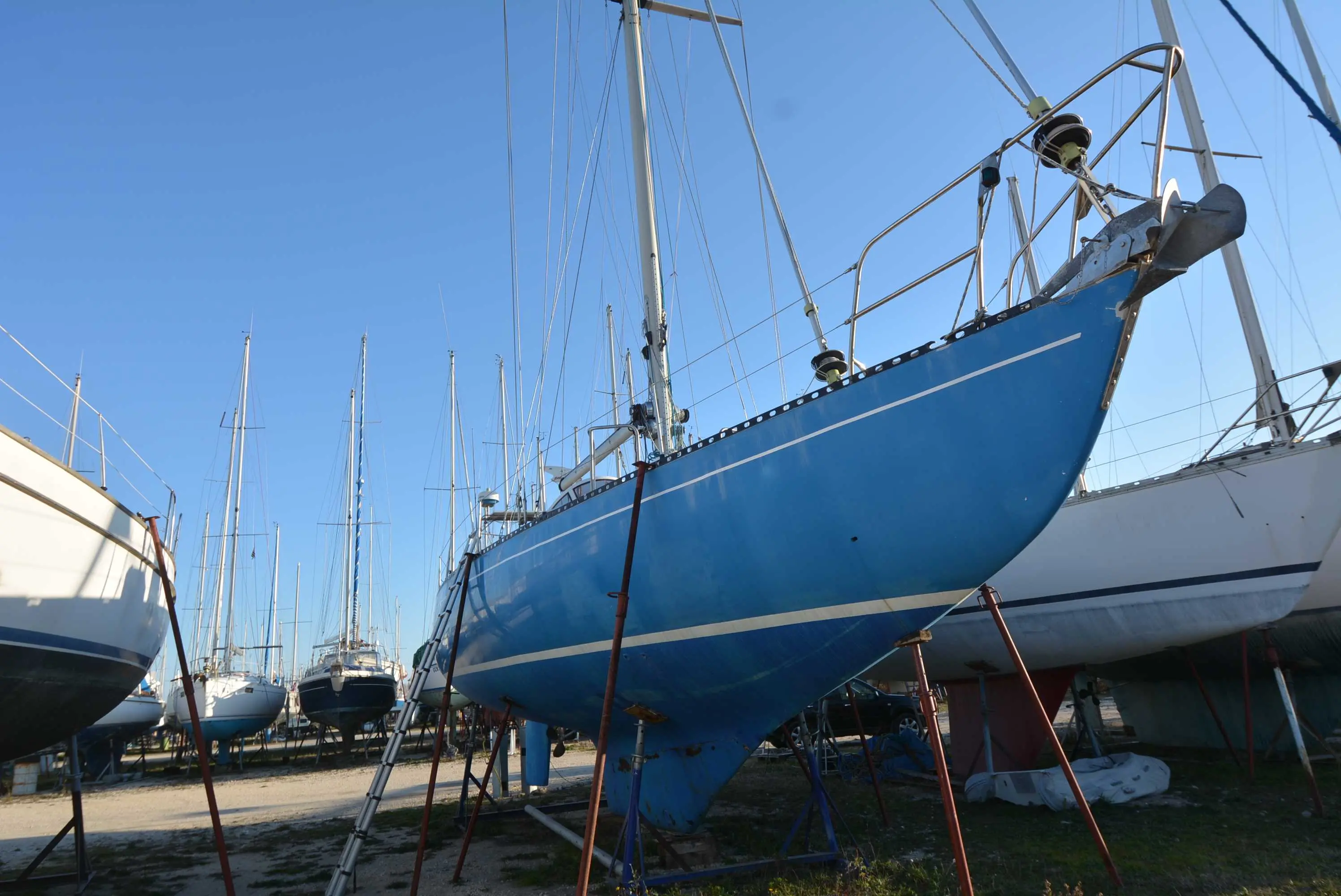 Delph 44 — Voilier bleu à terre, photographié de trois quarts avant dans un chantier naval.