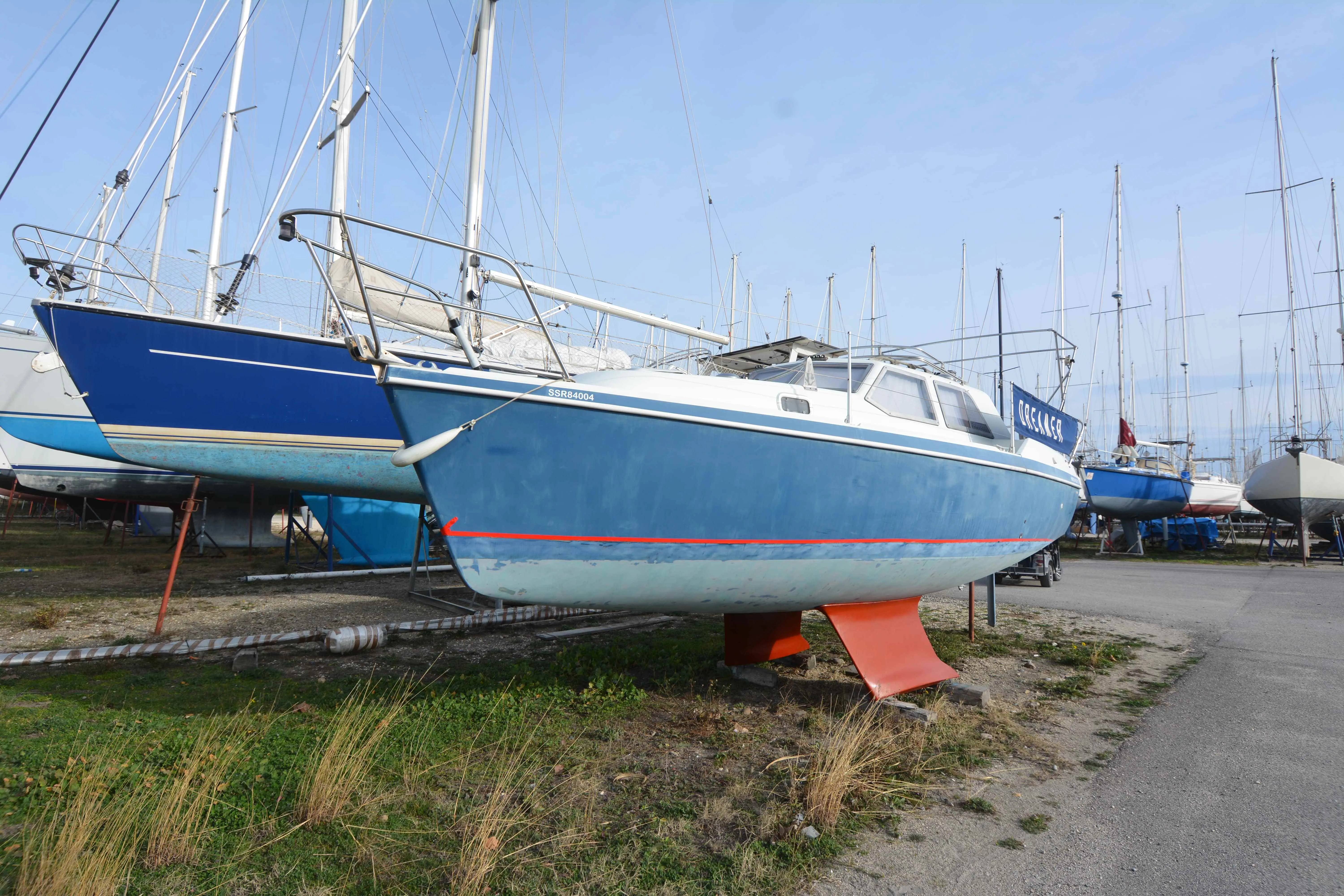 Hunter 27 — Voilier bleu et blanc photographié à terre dans un chantier naval.