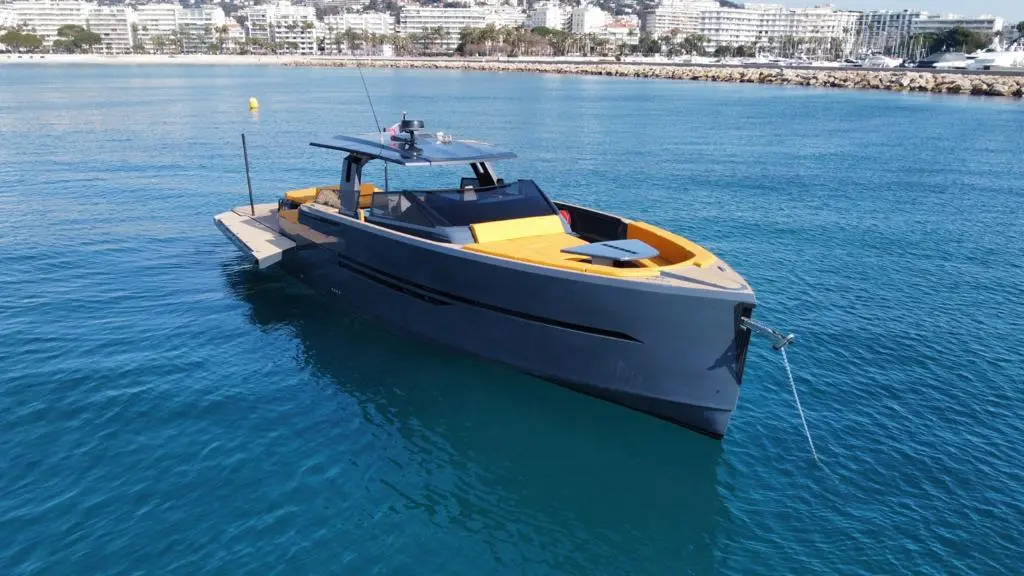 Okean 55 Open — Vedette à moteur grise et jaune amarrée dans une marina, vue en trois quarts avant.