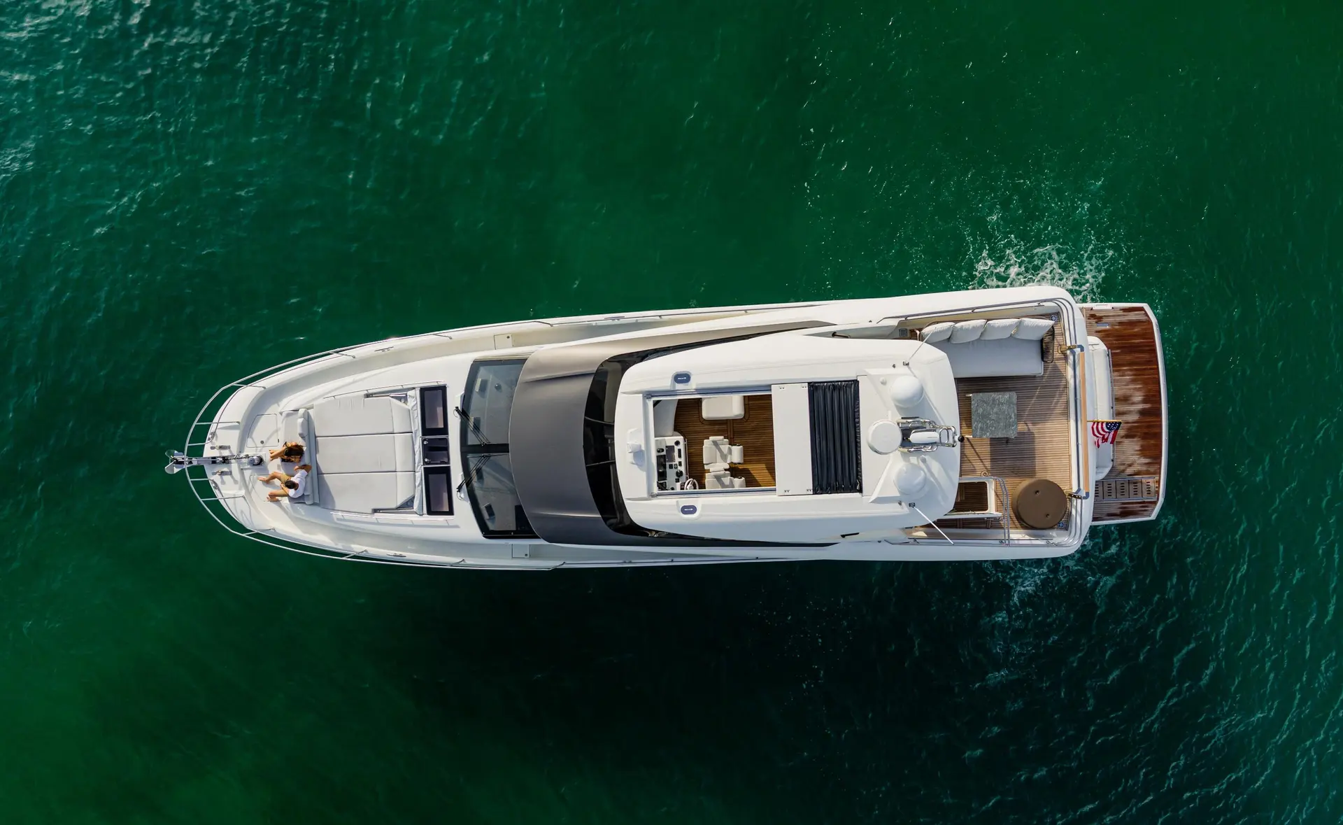 Prestige Yachts 690 — Vue aérienne d’un yacht blanc naviguant sur une eau turquoise.