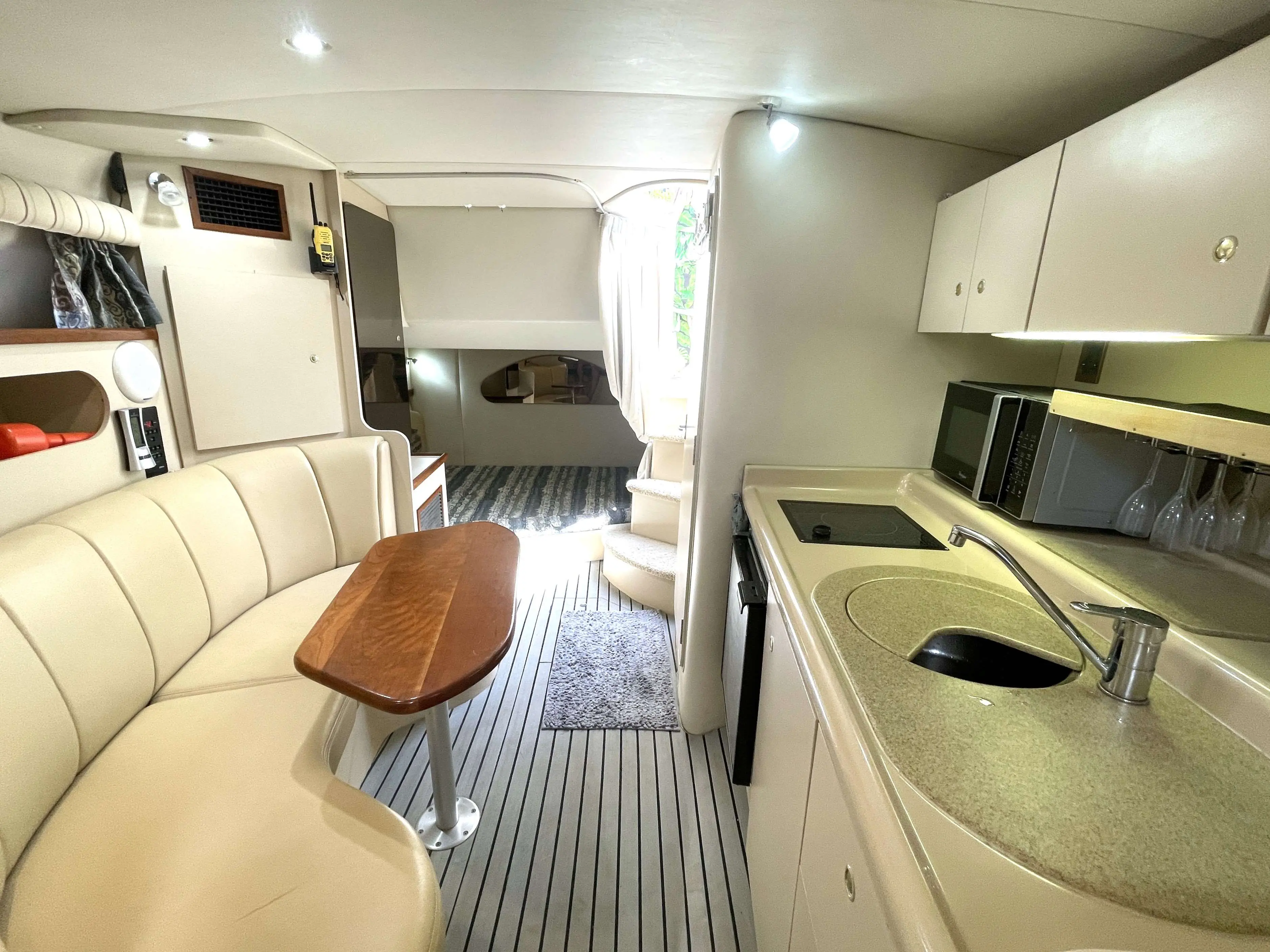Cruisers Yachts 3075 Express — Vue intérieure montrant le salon, la cuisine et l'accès à la cabine avant.