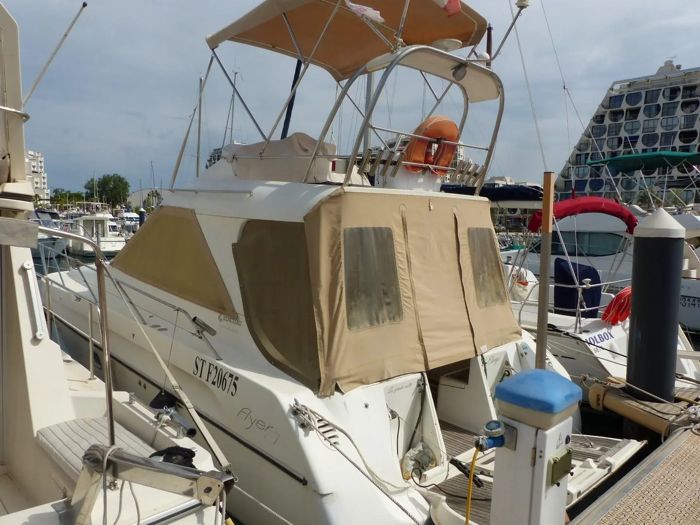 Beneteau Flyer F1 — Vue arrière trois-quarts d’un bateau à moteur amarré dans une marina.