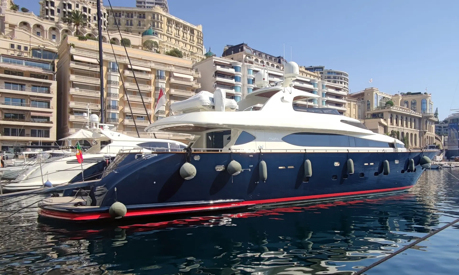 Maiora 31 — Yacht à moteur bleu et blanc amarré dans un port urbain.